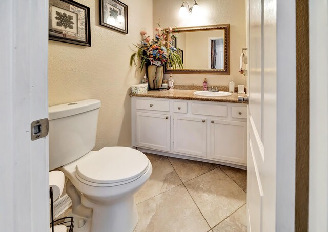 39884 Golfers Dr, Palmdale, CA 93551 - half bathroom with a textured wall, toilet, vanity, and tile patterned floors