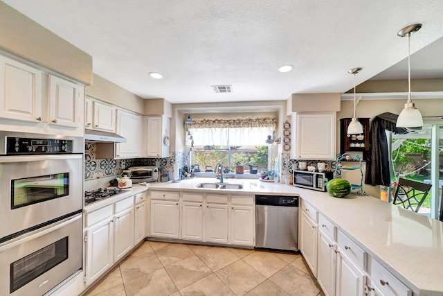 39884 Golfers Dr, Palmdale, CA 93551 - kitchen featuring stainless steel appliances, a sink, a peninsula, backsplash, and light countertops