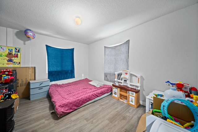 bedroom featuring light hardwood / wood-style flooring and a textured ceiling