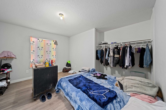 bedroom featuring hardwood / wood-style floors, a closet, and a textured ceiling