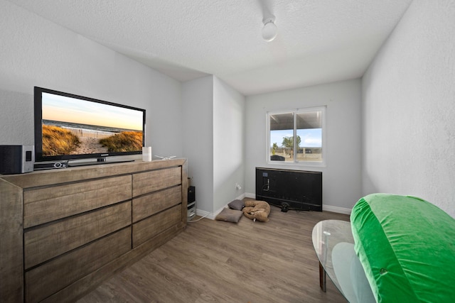 bedroom featuring wood-type flooring and a textured ceiling