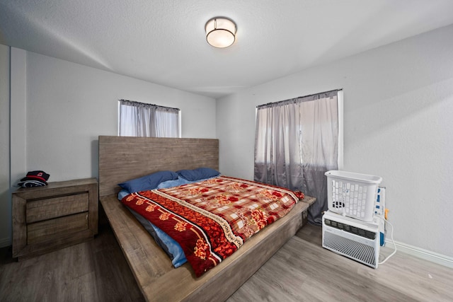 bedroom featuring wood-type flooring and a textured ceiling