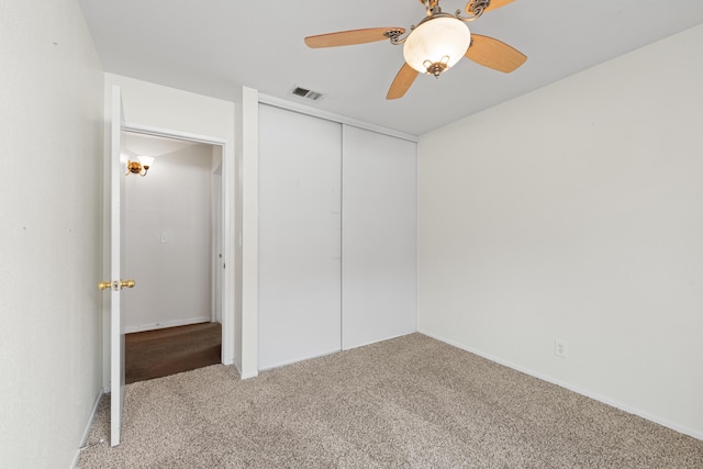 unfurnished bedroom featuring visible vents, a closet, ceiling fan, and carpet flooring