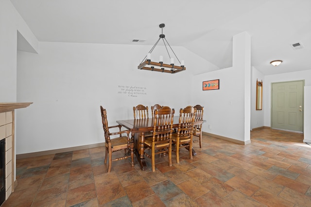 dining area featuring visible vents, baseboards, an inviting chandelier, and a fireplace