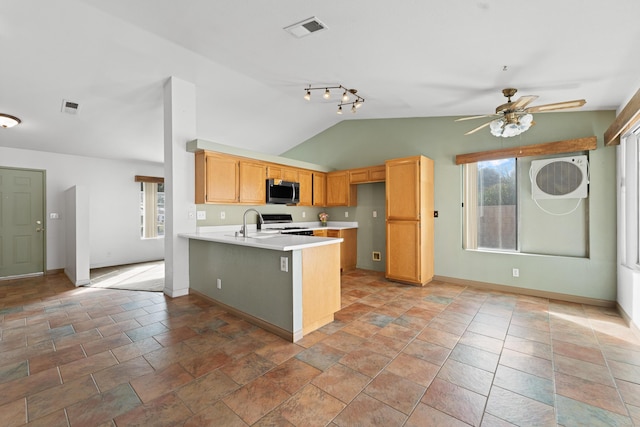 kitchen with visible vents, stainless steel microwave, a peninsula, light countertops, and range