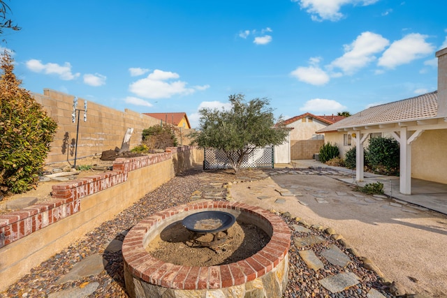 view of patio featuring a fenced backyard and an outdoor fire pit