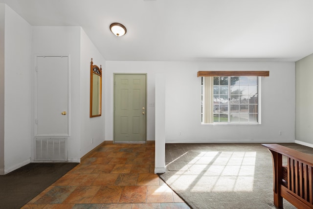 entryway with stone finish floor, baseboards, and visible vents