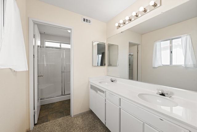 bathroom with a sink, visible vents, a stall shower, and double vanity