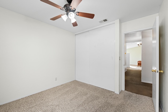 unfurnished bedroom with visible vents, carpet, a closet, and a ceiling fan