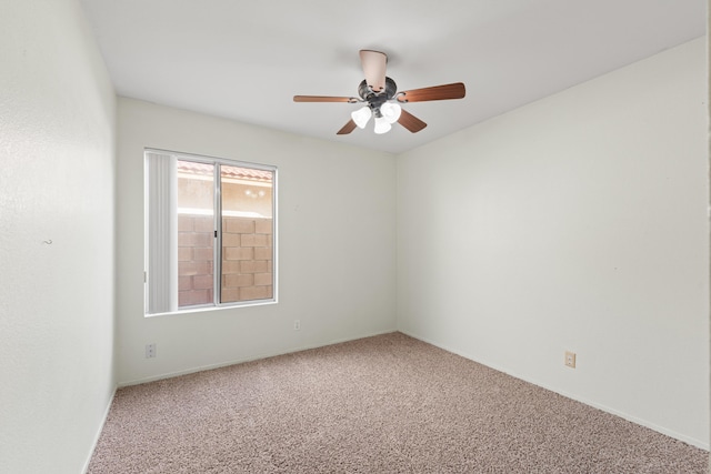 carpeted spare room featuring a ceiling fan