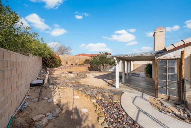 view of yard with a patio area, an outdoor fire pit, and a fenced backyard