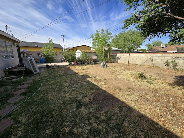 view of yard featuring a fenced backyard, an outdoor structure, and a storage shed
