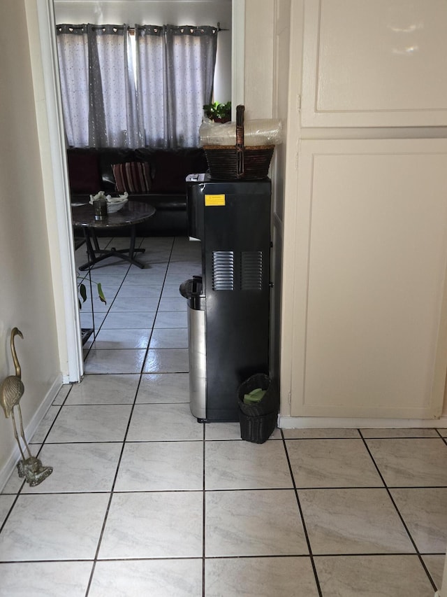 hall with baseboards and light tile patterned flooring