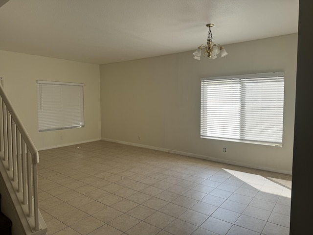 empty room featuring light tile patterned floors and a chandelier