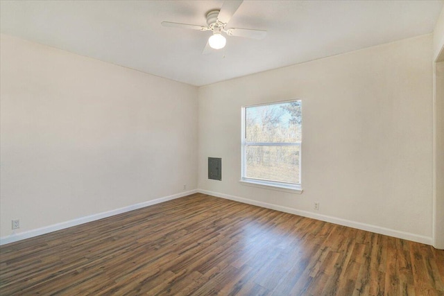 empty room with dark hardwood / wood-style flooring, electric panel, and ceiling fan