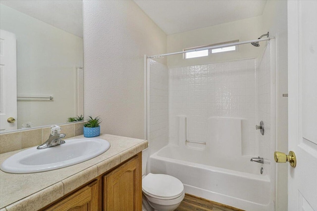 full bathroom featuring hardwood / wood-style floors, vanity,  shower combination, and toilet