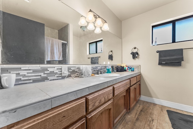 bathroom featuring hardwood / wood-style floors, decorative backsplash, and vanity