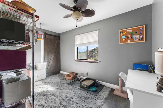 office space featuring a barn door and ceiling fan