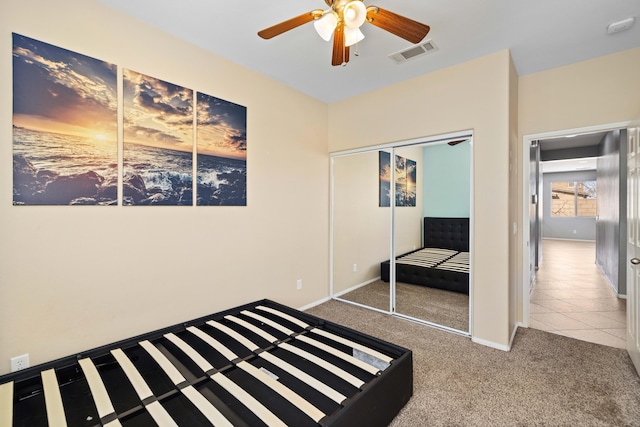 unfurnished bedroom with a closet, carpet flooring, baseboards, visible vents, and ceiling fan