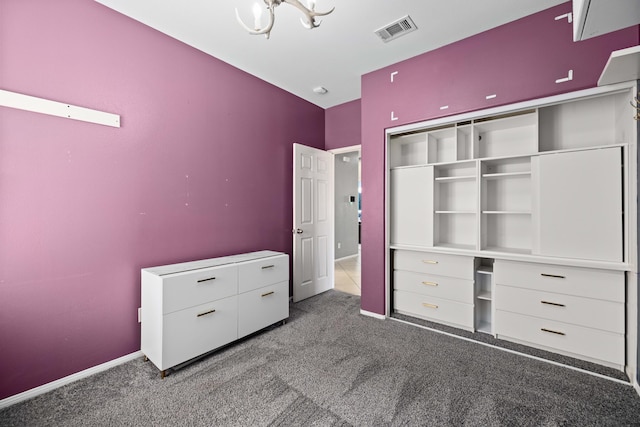 unfurnished bedroom featuring baseboards, visible vents, a notable chandelier, and carpet flooring