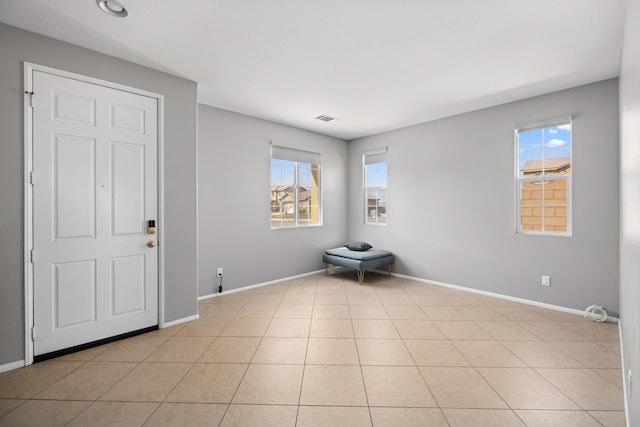 unfurnished room featuring light tile patterned floors, baseboards, and visible vents