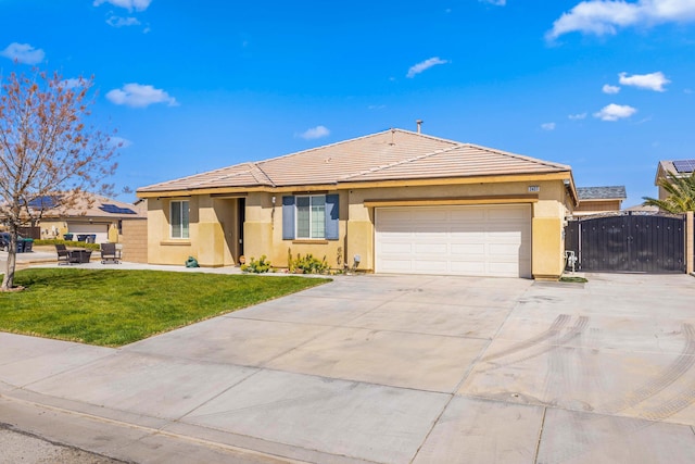 ranch-style home with a gate, an attached garage, stucco siding, a front lawn, and driveway
