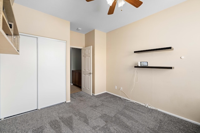 unfurnished bedroom featuring carpet flooring, baseboards, a closet, and ceiling fan