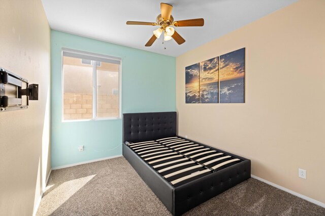carpeted bedroom featuring baseboards and ceiling fan