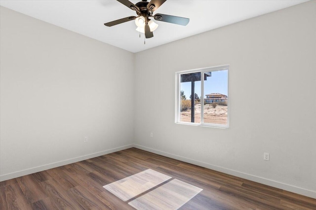 spare room featuring a ceiling fan, baseboards, and wood finished floors