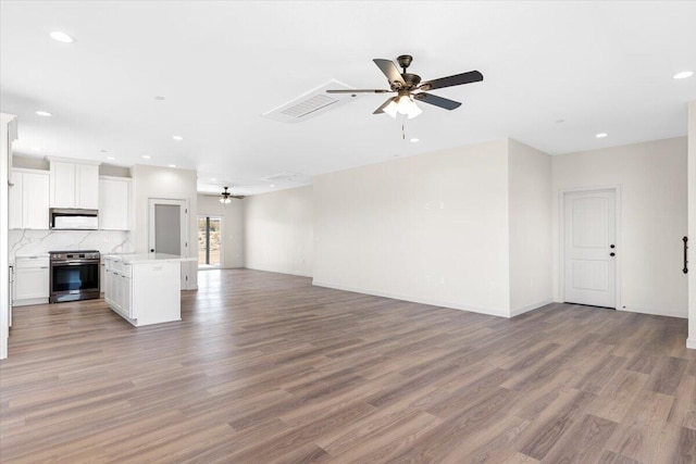unfurnished living room featuring ceiling fan, light wood-style flooring, recessed lighting, visible vents, and baseboards