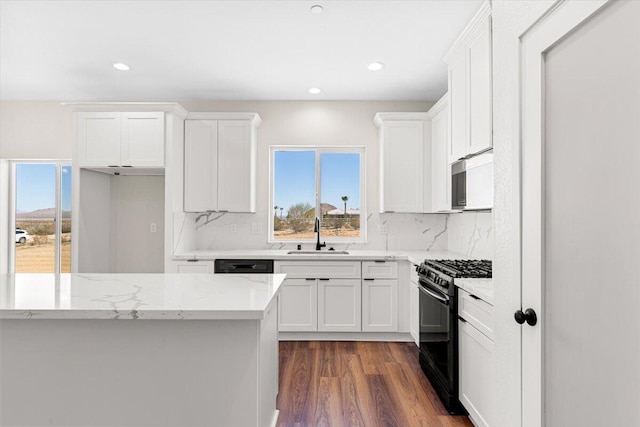 kitchen featuring decorative backsplash, dark wood-type flooring, white cabinets, a sink, and black appliances