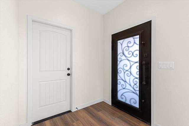 foyer entrance featuring dark wood-type flooring and baseboards