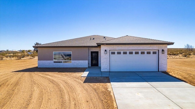 single story home with driveway, a garage, and stucco siding