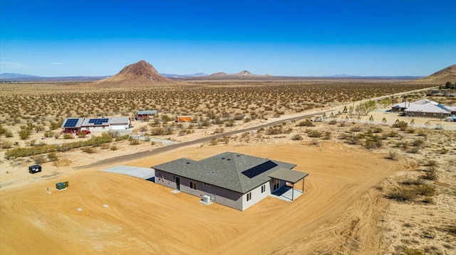 drone / aerial view featuring a rural view, a desert view, and a mountain view