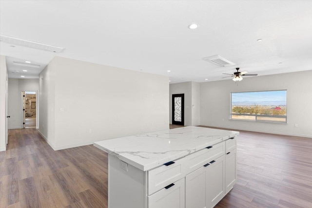 kitchen with ceiling fan, light wood-style flooring, open floor plan, a center island, and white cabinetry