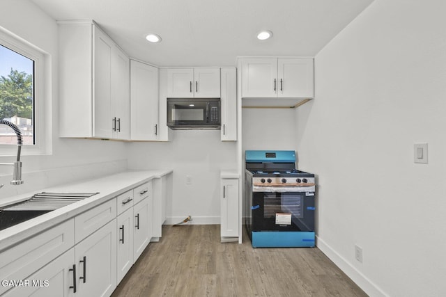 35114 E 82nd St Unit E, Littlerock, CA 93543 - kitchen featuring black microwave, gas range, white cabinetry, light wood-style floors, and light countertops