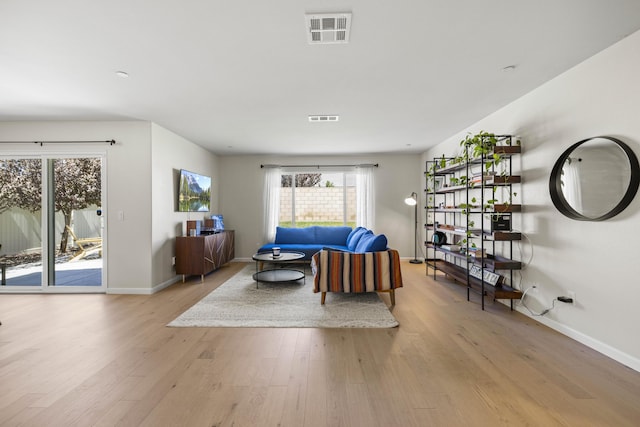 living room with plenty of natural light and light hardwood / wood-style flooring