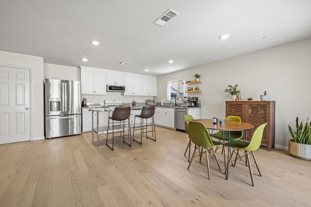 dining space with light hardwood / wood-style flooring