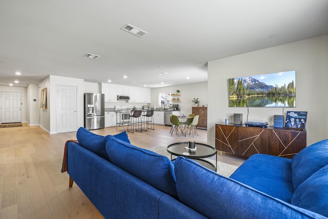 living room featuring sink and light hardwood / wood-style floors