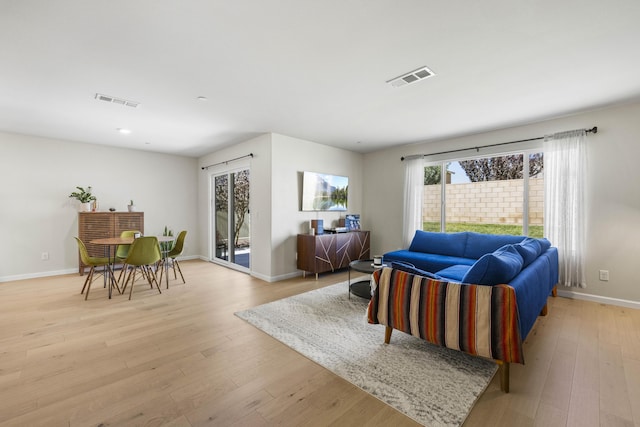 living room with a wealth of natural light and light hardwood / wood-style flooring