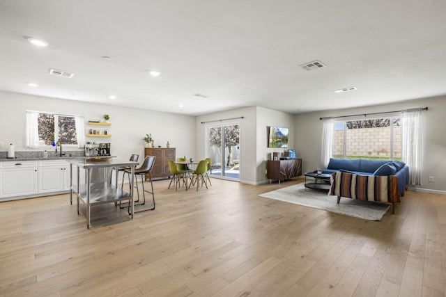 living room with sink and light hardwood / wood-style flooring