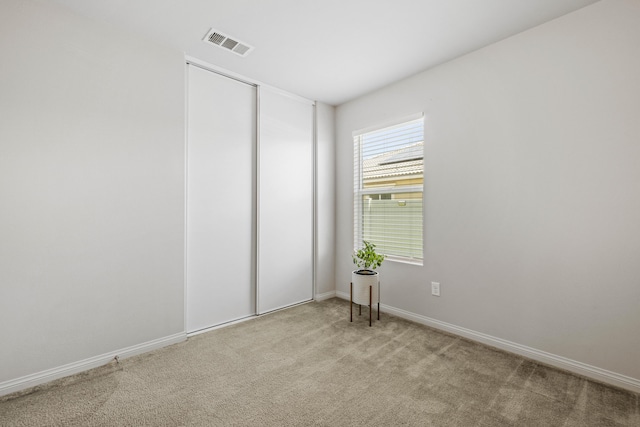 unfurnished room featuring light colored carpet