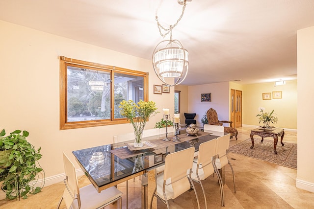 dining room with a chandelier and baseboards