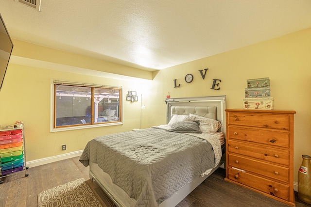 bedroom featuring dark wood-style flooring, visible vents, and baseboards