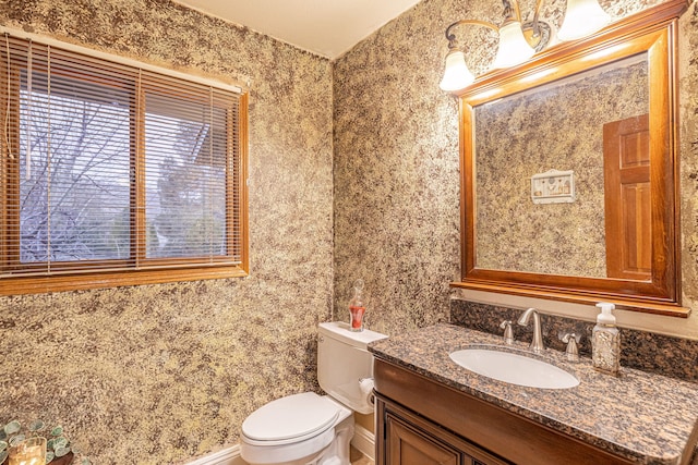 bathroom featuring baseboards, vanity, and toilet