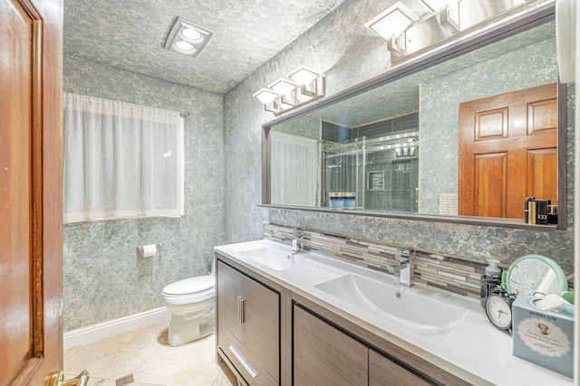 bathroom featuring double vanity, tile patterned flooring, a sink, and toilet