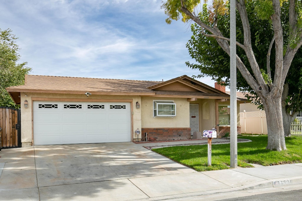 ranch-style house featuring a front yard and a garage