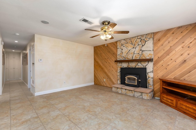 unfurnished living room featuring ceiling fan and wooden walls