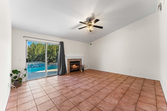 unfurnished living room featuring ceiling fan, lofted ceiling, a tile fireplace, and light tile patterned floors