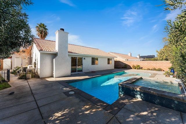 view of pool featuring a patio area and an in ground hot tub